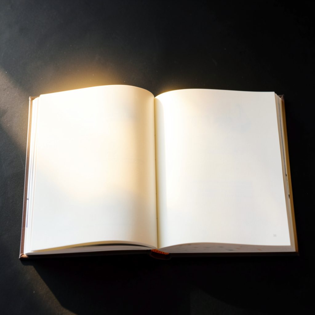An open manga volume with warm golden light spilling across the pages, set against a dark backdrop