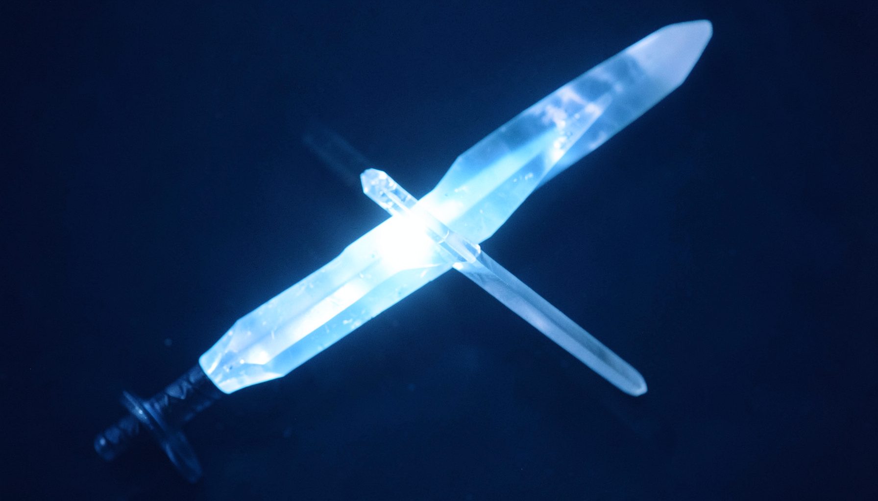 A moody, low-light scene with a crystalline sword glowing pale blue against a deep navy background, suggesting mystery and power.